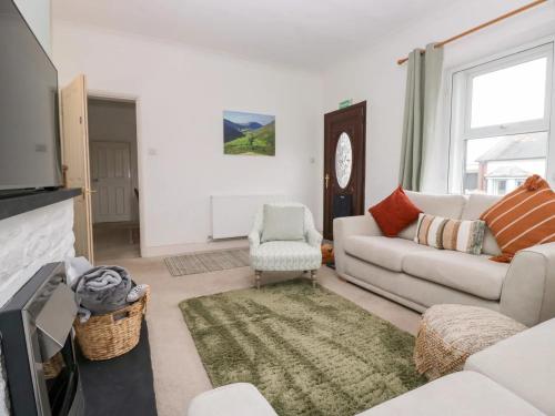 a living room with a couch and a tv at Cosy Cottage in Cumbria, West of Lake District in Broughton Moor