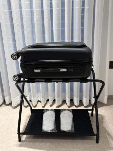 a suitcase sitting on a stand in front of a radiator at Boutique apartment in Rishon LeẔiyyon