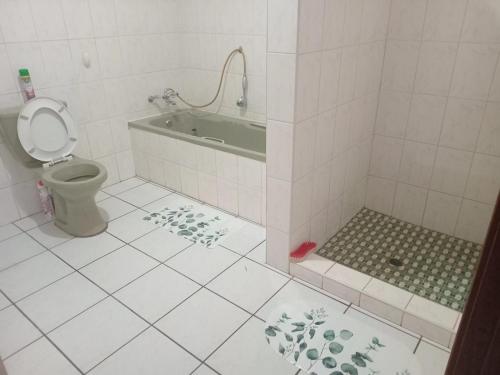 a bathroom with a bath tub and a toilet at Vervet Guesthouse in Port Edward