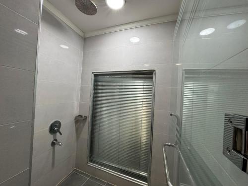 a bathroom with a shower and a window and a mirror at Al Jawahiri Hotel in Erbil