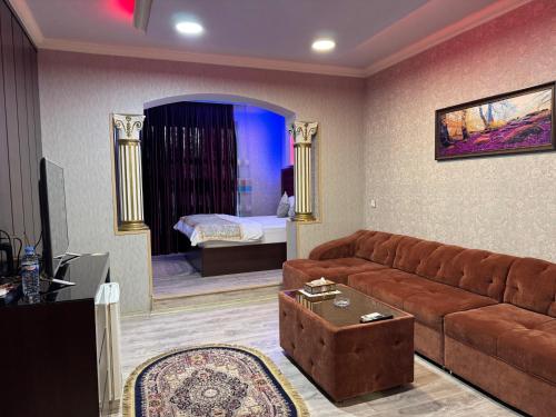 a living room with a couch and a bedroom at Al Jawahiri Hotel in Erbil