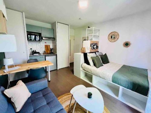 a bedroom with a bed and a blue couch at Ho Toulouse -Joli studio avec balcon in La Celle-sous-Gouzon
