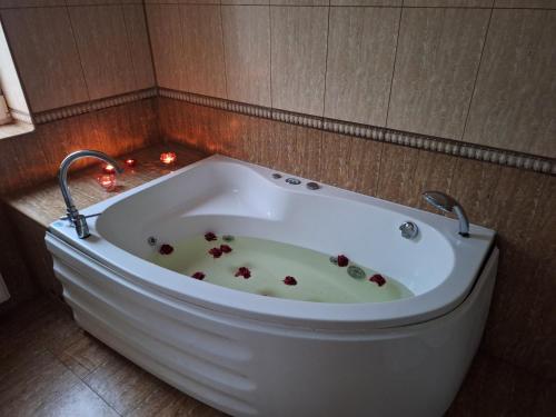 a bath tub in a bathroom with lights in it at Szmer Olzy Apartament in Istebna