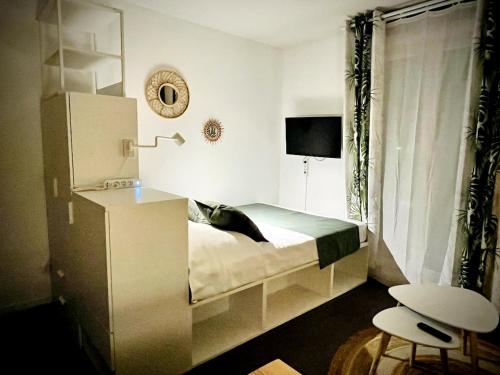 a bedroom with a bed and a table and a chair at Ho Toulouse -Joli studio avec balcon in La Celle-sous-Gouzon
