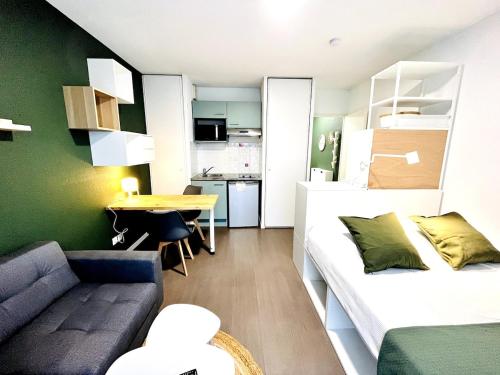 a living room with a couch and a table at Ho Toulouse -Joli studio avec balcon in La Celle-sous-Gouzon