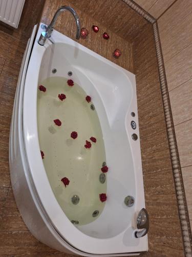 a white bath tub with red flowers in it at Szmer Olzy Apartament in Istebna