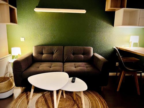 a living room with a couch and a table at Ho Toulouse -Joli studio avec balcon in La Celle-sous-Gouzon