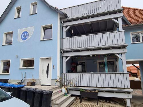 a blue house with a porch and a balcony at Moritz Apartments - Wohnung 15 in Küllstedt