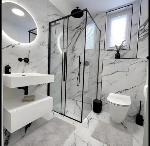 a white bathroom with a sink and a toilet at Cozy Getaway apartment in Ibadan
