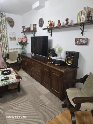 a living room with a television on a wooden cabinet at Apartamento Mirador del Pantano 1 in Vinuesa