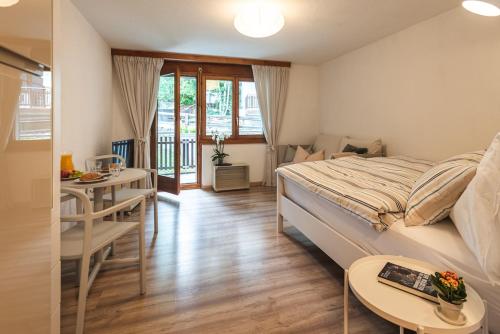 una camera da letto con un letto, un tavolo e una scrivania di Zermatt - well located and equipped studio a Zermatt