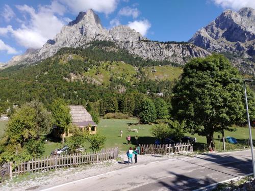 a group of people standing on the side of a road with mountains at Guest house 2 in Valbonë