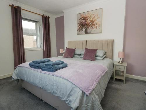 ein Schlafzimmer mit einem Bett mit blauen Handtüchern darauf in der Unterkunft Cosy Cottage in Cumbria, West of Lake District in Broughton Moor