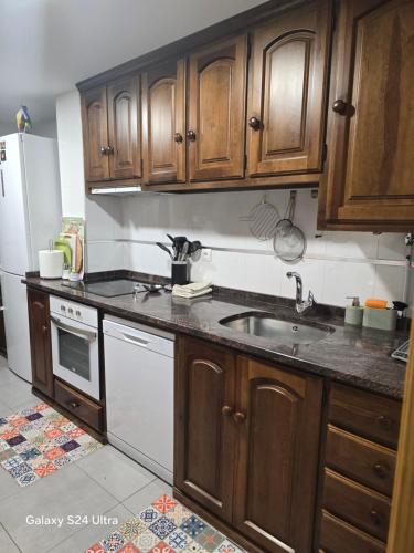 a kitchen with wooden cabinets and a sink at Apartamento Mirador del Pantano 1 in Vinuesa