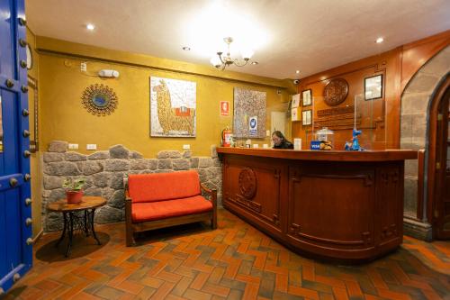 a kitchen with an orange chair and a bar at Amerindia in Cusco