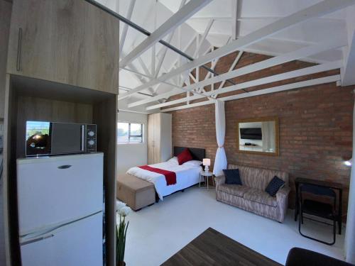 a bedroom with a bed and a brick wall at Quilla Quarters in Plumstead