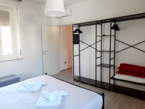 een slaapkamer met een wit bed en een rood kussen bij Domus 1 in Negrar