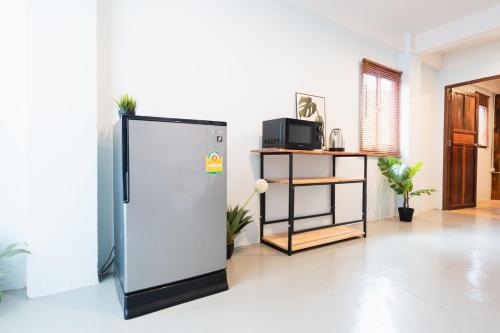 a refrigerator in a living room with a microwave at Dec Room at Shine Haus BangSue in Bang Su