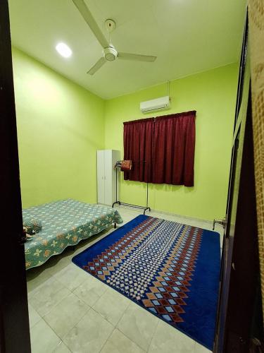 a room with two beds and a red curtain at DTM Homestay 1 in Tanah Merah