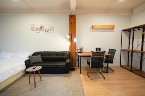 a bedroom with a couch and a table and a bed at Dec Room at Shine Haus BangSue in Bang Su