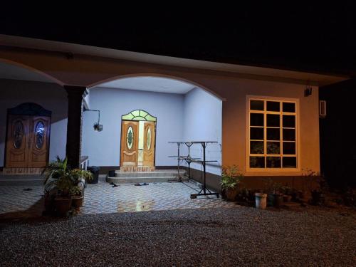 a room with a door in a house at night at DTM Homestay 1 in Tanah Merah