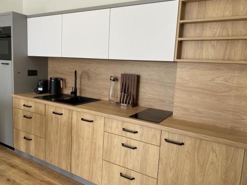 a kitchen with wooden cabinets and a counter top at Malé Lipno Apartment 225-7 Lipno Home in Černá v Pošumaví