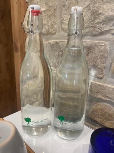 two glass bottles of water sitting on a table at Stunning location on Pendle Hill in Nelson