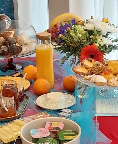 a table with food and a bottle of orange juice at Arts by Loulé - Alojamento de Charme in Loulé