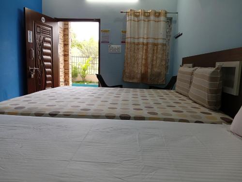 a bedroom with a large bed in a room at Sathyam Resorts in Dharmapuri