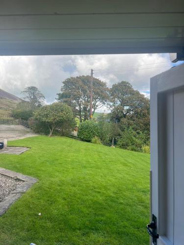 a view of a yard from an open window at Stunning location on Pendle Hill in Nelson