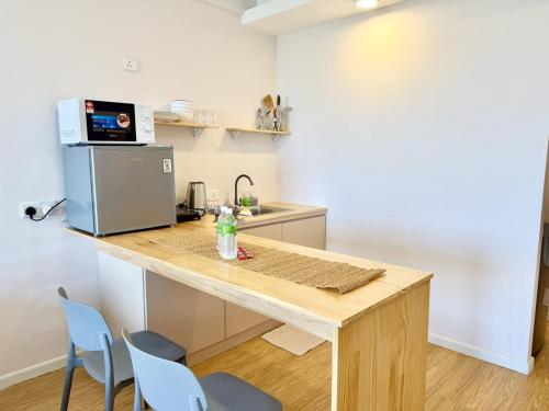 a kitchen with a wooden table and blue chairs at Deco Home @ Aru Suites in Kota Kinabalu