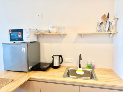 a kitchen counter with a sink and a refrigerator at Deco Home @ Aru Suites in Kota Kinabalu