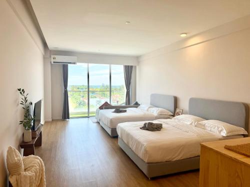 a hotel room with two beds and a large window at Deco Home @ Aru Suites in Kota Kinabalu
