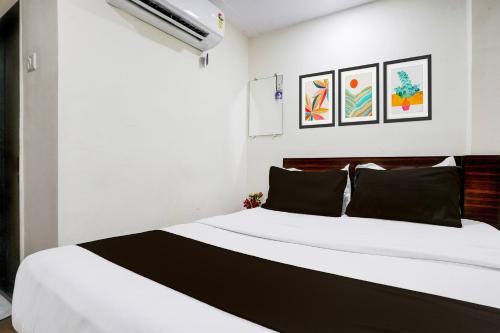 a bedroom with a large white bed with black pillows at Hotel O Grand Villa in Mumbai