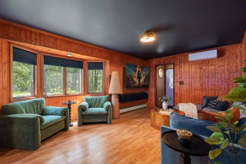 un salon avec des murs lambrissés de bois et un canapé et des chaises dans l'établissement Theater*2 Game Rooms *Sauna *Hot Tub*Fall Specials, à Blakeslee