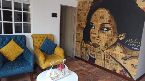 a living room with a couch and a large mural at Hotel Alcatraz in Yarumal
