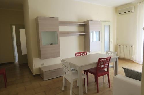 a dining room with a white table and chairs at Casa Geranio in Margherita di Savoia