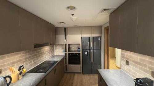 a kitchen with a stainless steel refrigerator and counters at Room in an 4BR High Rise with Burj Khalifa and Fountain Views in Dubai