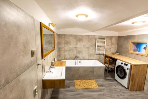 a bathroom with a sink and a washing machine at Chalet Malá Strana in Lučany nad Nisou