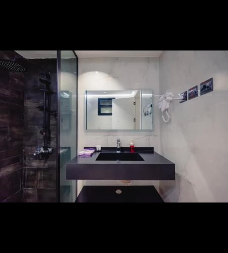 a bathroom with a sink and a mirror and a shower at Zad Marina Hotel in Kuwait