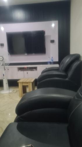 a row of black chairs in a room with a flat screen tv at Molayo Luxury Apartment Omolayo Estates Akobo Ojurin Ibadan in Ibadan