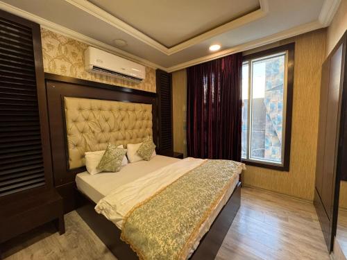 a bedroom with a bed and a window at Al Jawahiri Hotel in Erbil