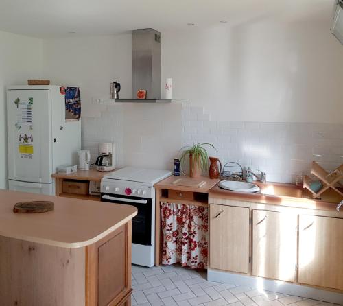 a kitchen with a white stove and a refrigerator at LES MIGLOU - Maison picarde entre Paris et la Champagne ! in Nogentel