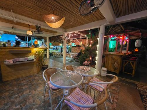 ラワイビーチにあるLeon Oasis Nai Harnのテーブルと椅子のあるレストラン、バー