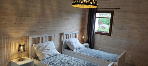 Un dormitorio con dos camas y una lámpara de araña. en Pod farárovou hôrkou, en Banská Štiavnica