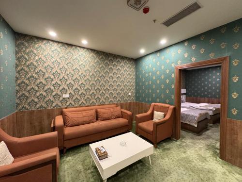 a hospital room with a couch and a bed at Al Jawahiri Hotel in Erbil