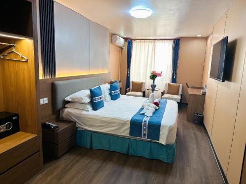 a hotel room with a large bed with blue pillows at Nanjing Restaurant & Motel in Kampala