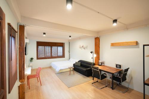 a room with a bed and a table and a couch at Dec Room at Shine Haus BangSue in Bang Su