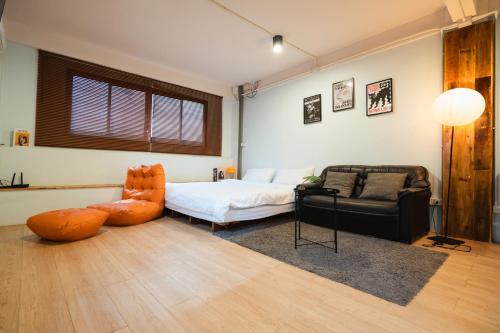a room with a bed and a couch and a chair at Dec Room at Shine Haus BangSue in Bang Su