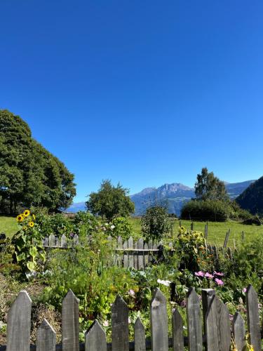 a fence in front of a garden with flowers at Bergsuites Unterweger in Tisens